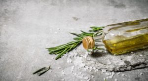 Olive oil in bottle with rosemary and salt.