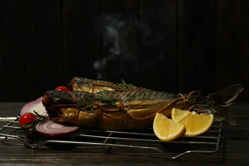 Concept of tasty food with smoked mackerel on wooden table