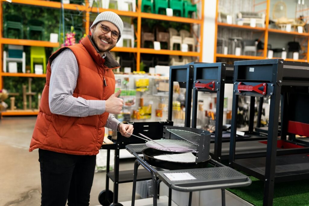 a satisfied customer in a hypermarket chooses a barbecue grill for his backyard