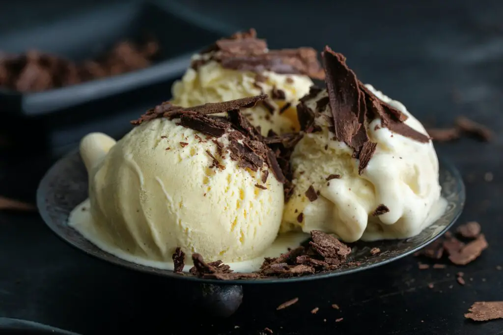 Vanilla ice cream scoops on dark plate