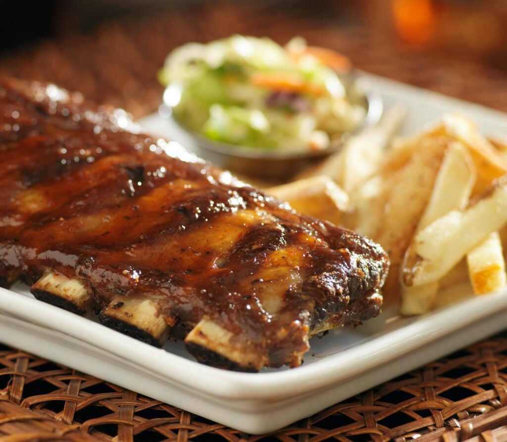 full rack of baby back ribs in barbecue sauce close up